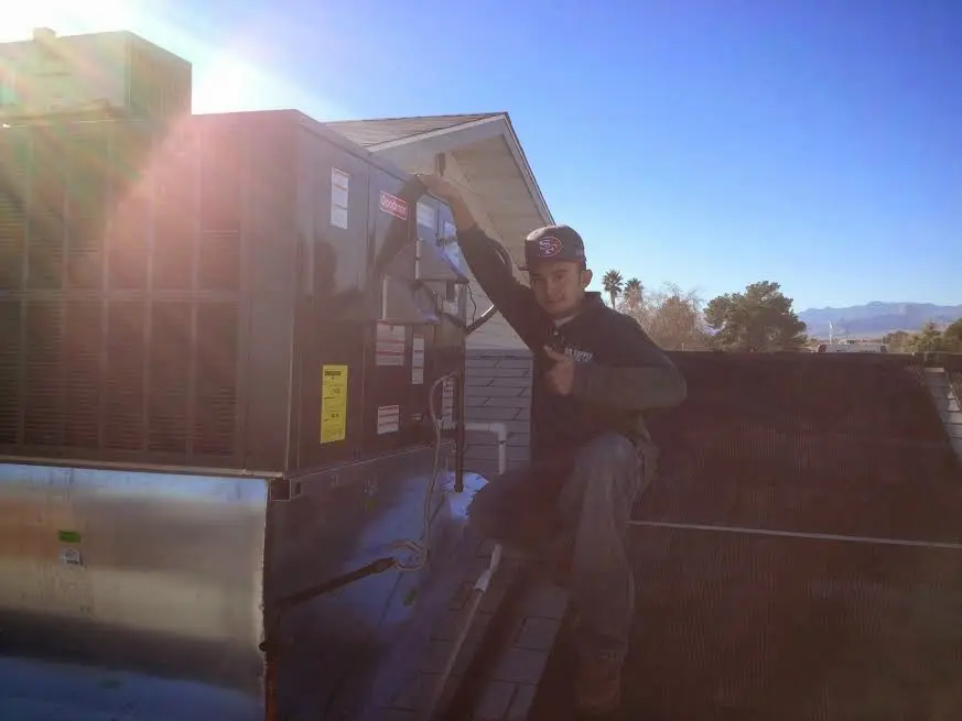HVAC technician performing Air Duct Cleaning on a rooftop unit in Hazle